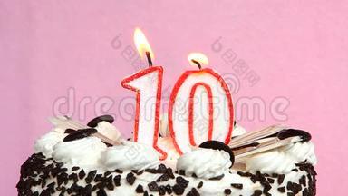 十<strong>周年庆</strong>典，蛋糕和蜡烛放在粉色背景上